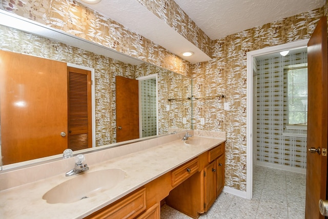 2622 Williams Grant St, Sugar Land, TX 77479 - bathroom featuring double vanity, a textured ceiling, and wallpapered walls