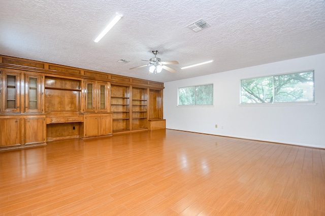 2622 Williams Grant St, Sugar Land, TX 77479 - spare room with a ceiling fan, a textured ceiling, built in features, and light wood-type flooring