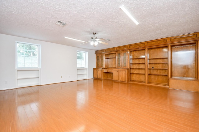 2622 Williams Grant St, Sugar Land, TX 77479 - unfurnished living room with built in features, a ceiling fan, a textured ceiling, and light wood finished floors