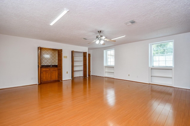 2622 Williams Grant St, Sugar Land, TX 77479 - spare room featuring a textured ceiling, a ceiling fan, healthy amount of natural light, and light wood-style flooring