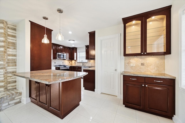 4530 T C Jester Blvd, Houston, TX 77018 - kitchen with stainless steel appliances, backsplash, glass insert cabinets, a peninsula, and light stone countertops