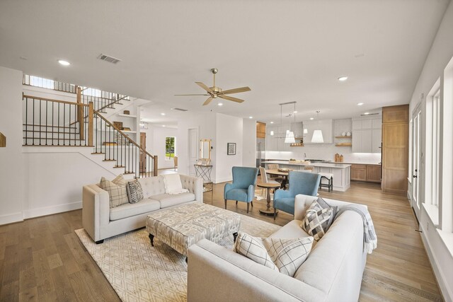 5317 Schumacher Ln, Houston, TX 77056 - living area featuring light wood-type flooring, stairway, recessed lighting, and a ceiling fan