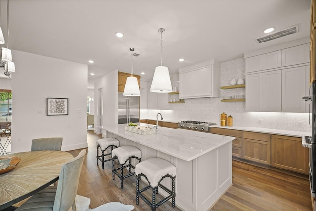 5317 Schumacher Ln, Houston, TX 77056 - kitchen with stainless steel appliances, open shelves, dark wood finished floors, tasteful backsplash, and light stone countertops