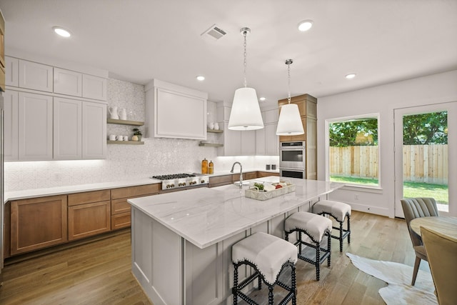 5317 Schumacher Ln, Houston, TX 77056 - kitchen featuring open shelves, tasteful backsplash, a breakfast bar area, light stone counters, and light wood-style flooring