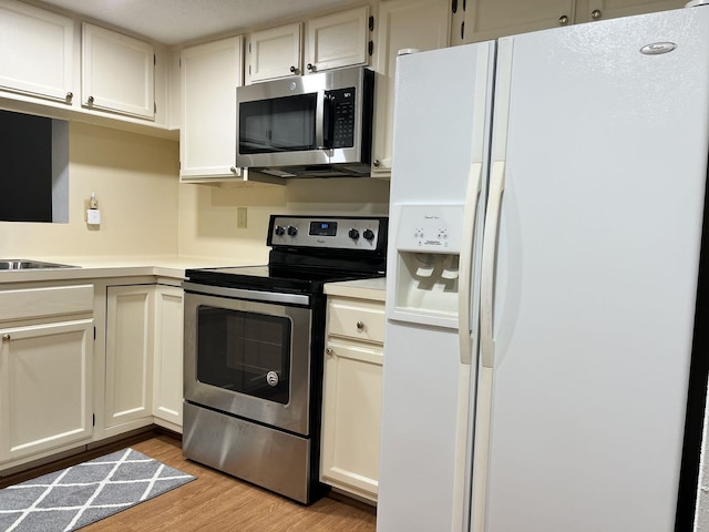 14911 Wunderlich Dr Unit 211, Houston, TX 77069 - kitchen with appliances with stainless steel finishes, light wood-style flooring, and light countertops