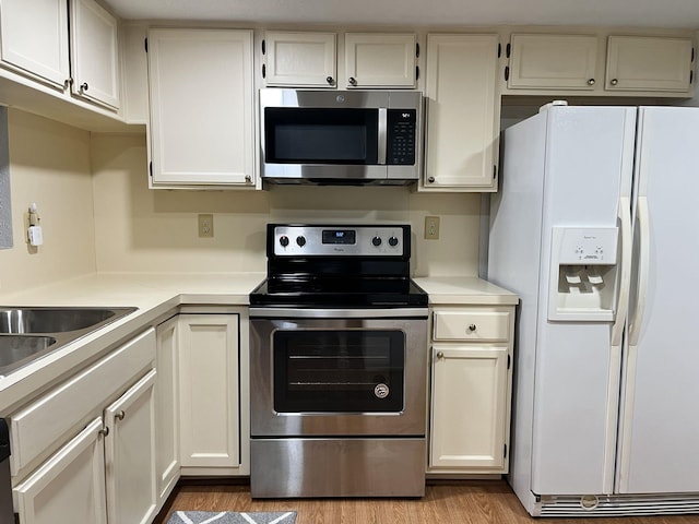 14911 Wunderlich Dr Unit 211, Houston, TX 77069 - kitchen with stainless steel appliances, light countertops, wood finished floors, and white cabinetry
