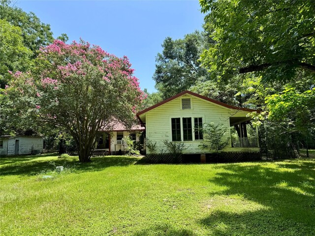 193 Corry Jones, Livingston, TX 77351 - back of house featuring a lawn