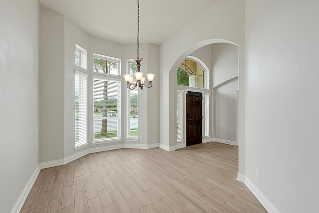 20010 Barrow Edge Ln, Cypress, TX 77433 - entrance foyer with a chandelier, light wood-type flooring, a high ceiling, and arched walkways