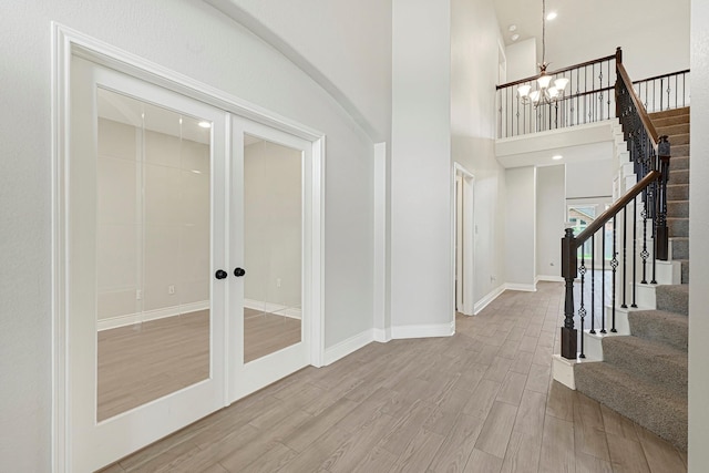 20010 Barrow Edge Ln, Cypress, TX 77433 - entrance foyer featuring wood finished floors, french doors, a chandelier, a high ceiling, and stairs