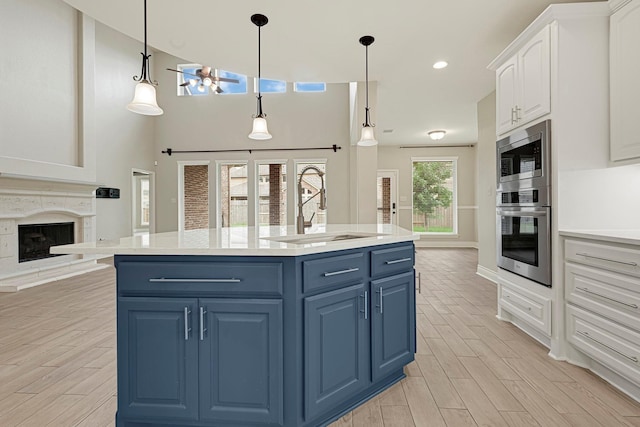 20010 Barrow Edge Ln, Cypress, TX 77433 - kitchen featuring appliances with stainless steel finishes, blue cabinetry, white cabinetry, light countertops, and a kitchen island with sink