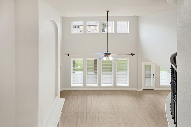 20010 Barrow Edge Ln, Cypress, TX 77433 - unfurnished living room featuring a ceiling fan, a towering ceiling, and plenty of natural light