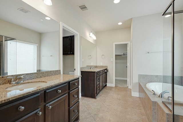 20010 Barrow Edge Ln, Cypress, TX 77433 - full bath featuring two vanities, a garden tub, tile patterned floors, a spacious closet, and recessed lighting