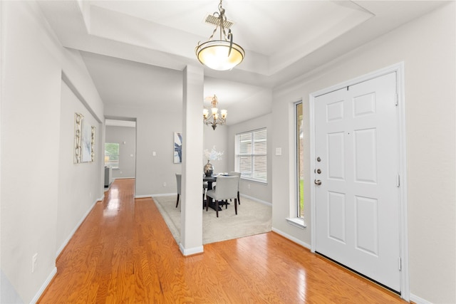 99 E Foxbriar Forest Cir, The Woodlands, TX 77382 - foyer featuring light wood-style floors, a chandelier, plenty of natural light, and a tray ceiling