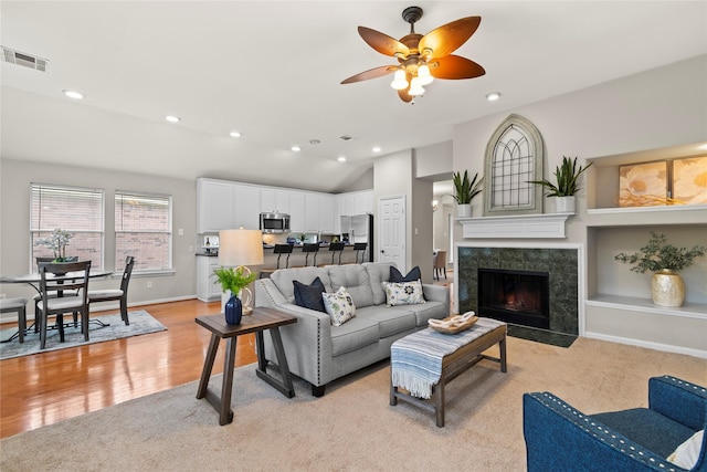 99 E Foxbriar Forest Cir, The Woodlands, TX 77382 - living area with a ceiling fan, recessed lighting, a tile fireplace, lofted ceiling, and light colored carpet