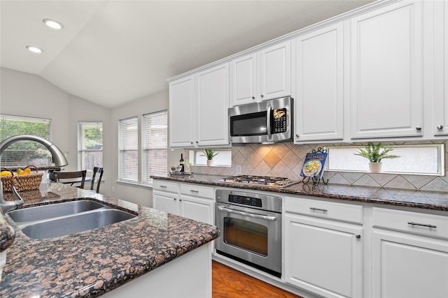 99 E Foxbriar Forest Cir, The Woodlands, TX 77382 - kitchen with appliances with stainless steel finishes, lofted ceiling, backsplash, recessed lighting, and white cabinetry