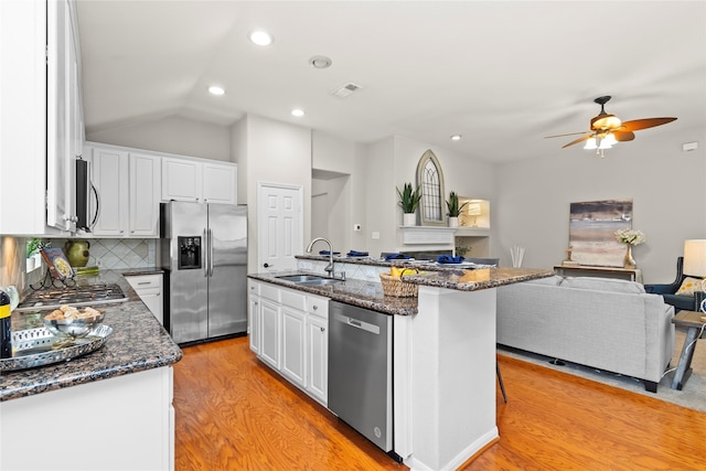 99 E Foxbriar Forest Cir, The Woodlands, TX 77382 - kitchen with stainless steel appliances, open floor plan, light wood-style flooring, white cabinetry, and ceiling fan