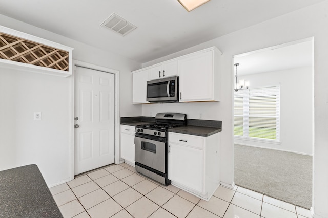 16323 Tiburon Way, Houston, TX 77053 - kitchen featuring stainless steel appliances, dark countertops, white cabinets, a chandelier, and light tile patterned floors