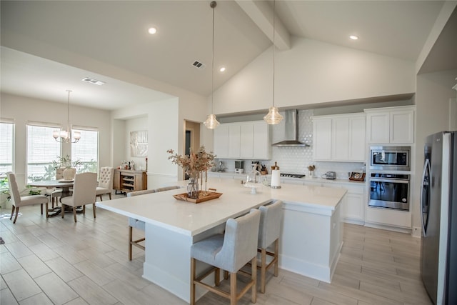 15138 Botanical Garden Dr, Conroe, TX 77302 - kitchen featuring stainless steel appliances, wall chimney exhaust hood, beam ceiling, a breakfast bar, and light countertops