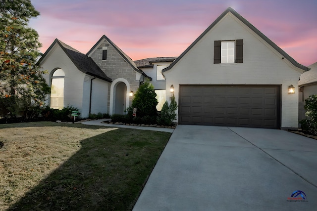 15138 Botanical Garden Dr, Conroe, TX 77302 - french provincial home with concrete driveway, a front yard, an attached garage, and stone siding