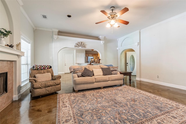 15631 Fir Rd, Santa Fe, TX 77517 - living room featuring arched walkways, ornamental molding, a ceiling fan, and a tiled fireplace