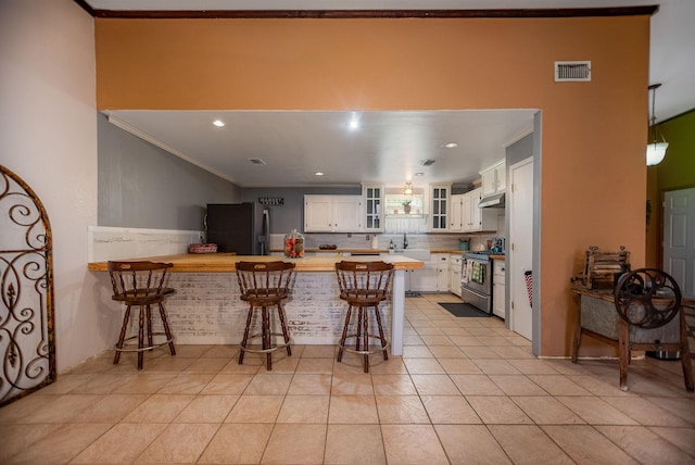925 Royal Rd, Port Lavaca, TX 77979 - kitchen featuring black fridge with ice dispenser, stainless steel gas range, crown molding, a peninsula, and under cabinet range hood