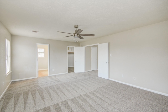 7255 Liberty Mesa Ln, Houston, TX 77049 - unfurnished bedroom featuring carpet flooring, a ceiling fan, and a walk in closet