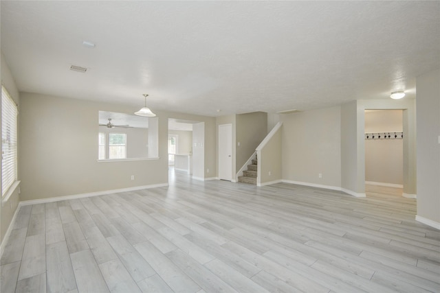 7255 Liberty Mesa Ln, Houston, TX 77049 - unfurnished living room featuring stairs, light wood-style flooring, and ceiling fan