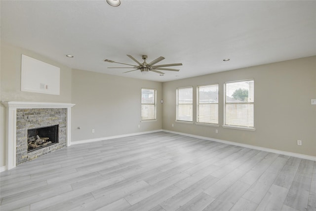 7255 Liberty Mesa Ln, Houston, TX 77049 - unfurnished living room featuring a ceiling fan, light wood-type flooring, a stone fireplace, and recessed lighting