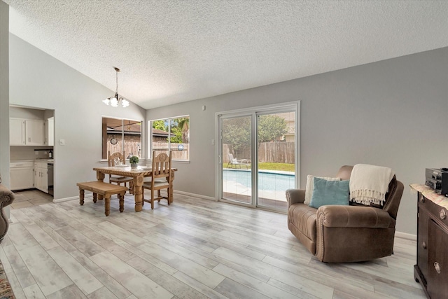 15707 Spring Forest Dr, Houston, TX 77059 - dining room featuring a textured ceiling, a chandelier, light wood-style floors, and vaulted ceiling