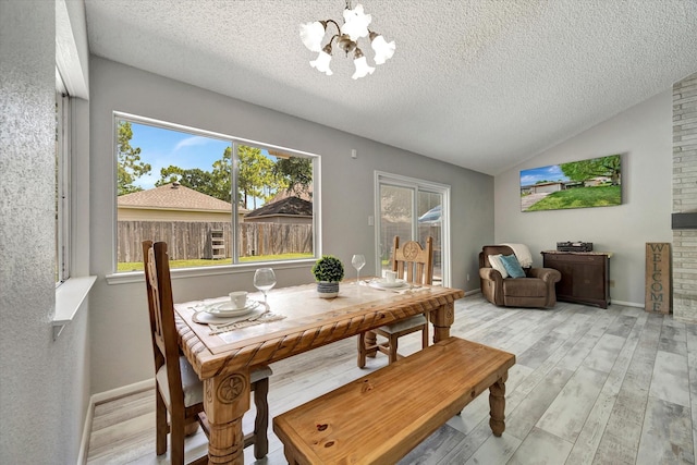 15707 Spring Forest Dr, Houston, TX 77059 - dining area featuring a chandelier, a textured ceiling, light wood-type flooring, and lofted ceiling