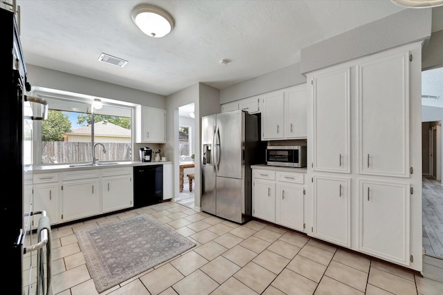 15707 Spring Forest Dr, Houston, TX 77059 - kitchen with stainless steel appliances, white cabinets, light countertops, and light tile patterned floors