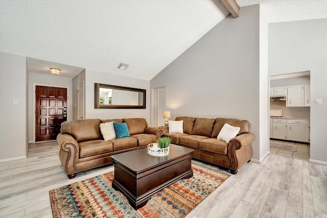 15707 Spring Forest Dr, Houston, TX 77059 - living area with light wood-type flooring, beam ceiling, high vaulted ceiling, and a textured ceiling