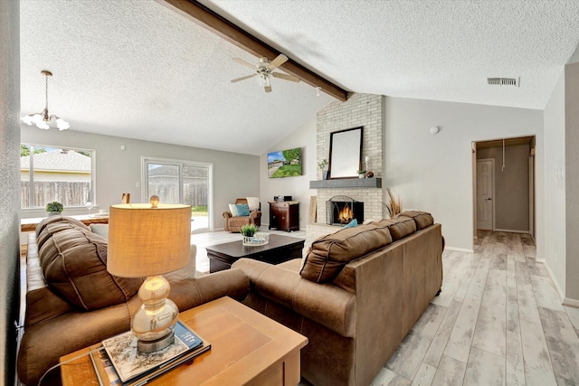 15707 Spring Forest Dr, Houston, TX 77059 - living room with a textured ceiling, light wood-style flooring, a brick fireplace, ceiling fan, and a chandelier