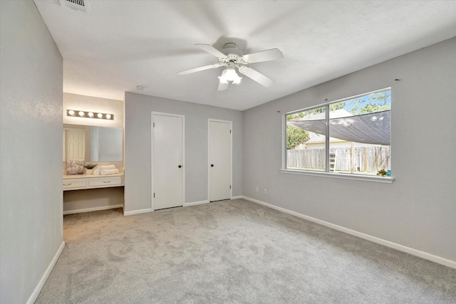 15707 Spring Forest Dr, Houston, TX 77059 - unfurnished bedroom with light colored carpet, two closets, ensuite bathroom, and ceiling fan
