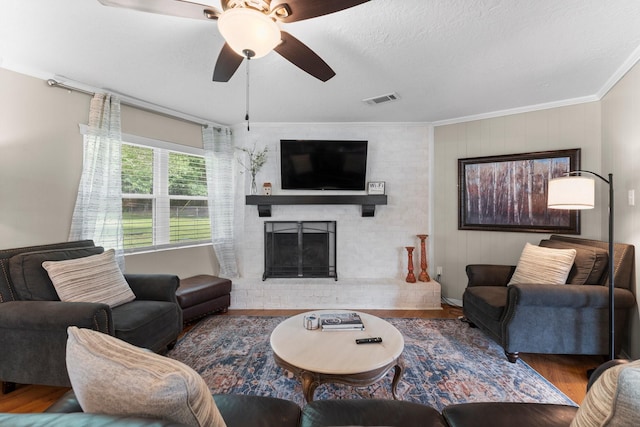 32047 S Wiggins St, Magnolia, TX 77355 - living area featuring wood finished floors, ornamental molding, a fireplace, and ceiling fan