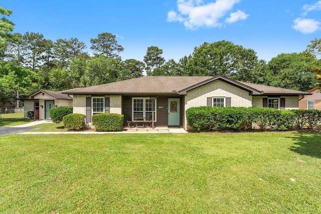 32047 S Wiggins St, Magnolia, TX 77355 - ranch-style house with brick siding, a front lawn, a porch, and a garage