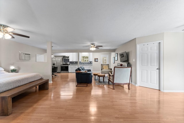 32047 S Wiggins St, Magnolia, TX 77355 - living area featuring ceiling fan, an AC wall unit, and light wood-style floors