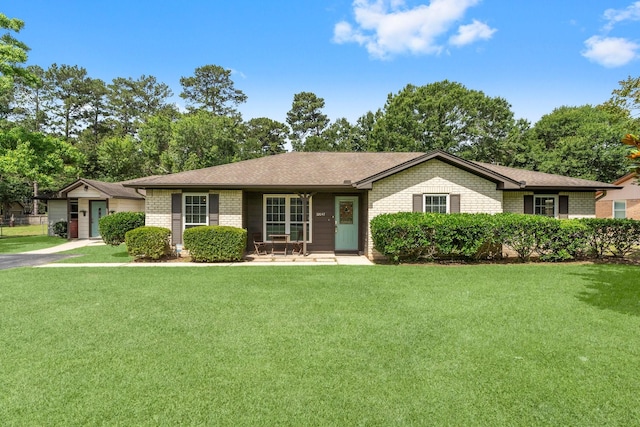 32047 S Wiggins St, Magnolia, TX 77355 - ranch-style house featuring a front yard, brick siding, covered porch, and a shingled roof