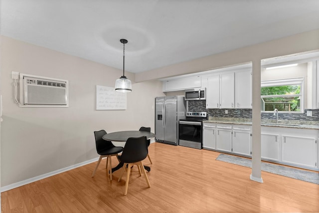 32047 S Wiggins St, Magnolia, TX 77355 - kitchen featuring appliances with stainless steel finishes, tasteful backsplash, and light wood-style flooring