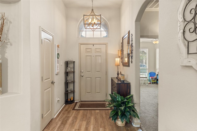 18715 Deer Trace Dr, Crosby, TX 77532 - foyer entrance featuring arched walkways, wood finished floors, a chandelier, and a ceiling fan