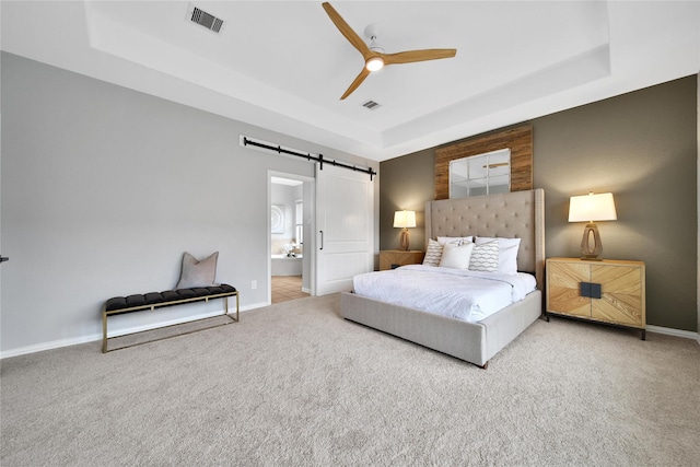 14314 Prosper Ridge Dr, Cypress, TX 77429 - bedroom featuring a barn door, a tray ceiling, carpet, and ensuite bathroom
