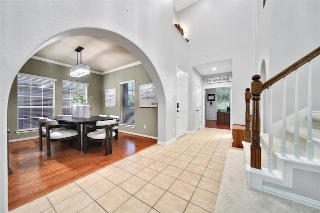 14314 Prosper Ridge Dr, Cypress, TX 77429 - dining area with light tile patterned floors, arched walkways, stairway, and crown molding
