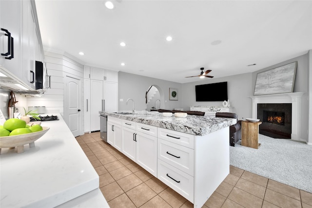 14314 Prosper Ridge Dr, Cypress, TX 77429 - kitchen with light tile patterned floors, a ceiling fan, dishwasher, recessed lighting, and a high end fireplace