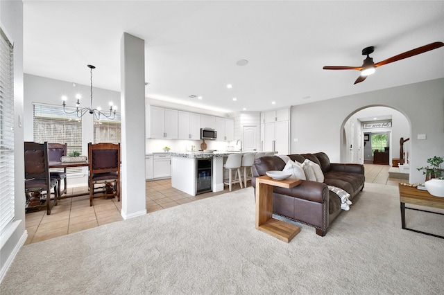 14314 Prosper Ridge Dr, Cypress, TX 77429 - living room featuring light tile patterned floors, a chandelier, light colored carpet, arched walkways, and plenty of natural light