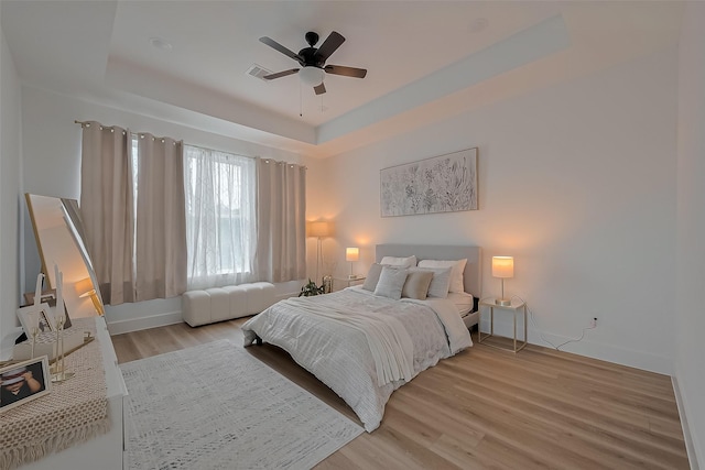 776 Mansfield St, Houston, TX 77091 - bedroom featuring a tray ceiling, light wood-style flooring, and a ceiling fan