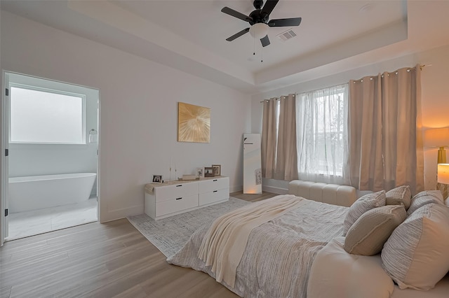 776 Mansfield St, Houston, TX 77091 - bedroom featuring a tray ceiling, light wood-type flooring, and a ceiling fan