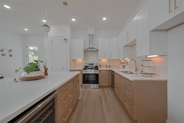 776 Mansfield St, Houston, TX 77091 - kitchen featuring stainless steel appliances, wall chimney range hood, wine cooler, light wood-style flooring, and light countertops