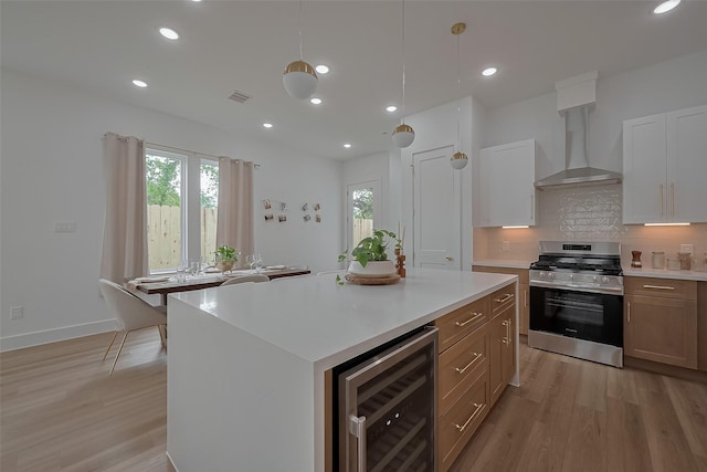 776 Mansfield St, Houston, TX 77091 - kitchen with gas stove, beverage cooler, wall chimney range hood, light wood finished floors, and light countertops