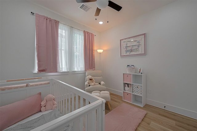 776 Mansfield St, Houston, TX 77091 - bedroom featuring a nursery area, light wood-type flooring, and a ceiling fan