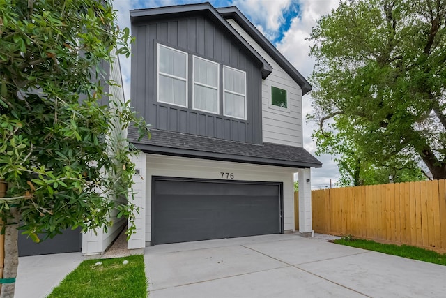 776 Mansfield St, Houston, TX 77091 - view of front of house with board and batten siding, an attached garage, driveway, and a shingled roof